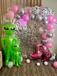 an alien themed birthday party with balloons, decorations and confetti on the table