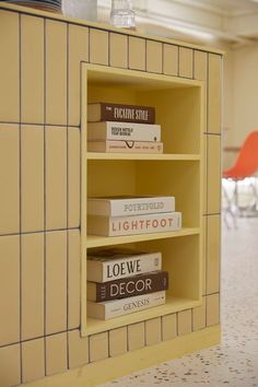 a yellow shelf with books on it in a room