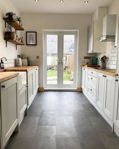 a kitchen with white cabinets and gray flooring