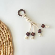 a rope with wooden beads hanging from it next to a woven basket on the table