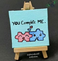 an easel with a painting on it that says you complete me