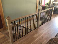 a wooden staircase with black iron railings and wood flooring