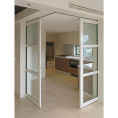 an empty room with sliding glass doors leading to the kitchen and living area in the background