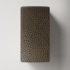 a flask shaped like a snake skin pattern is mounted on the side of a wall