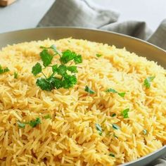 a pan filled with yellow rice and parsley