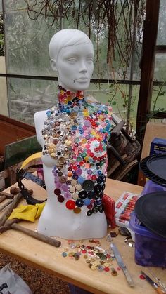 a mannequin is covered with buttons and other things to make it look like someones head