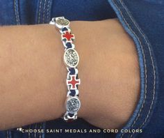 "INTERNATIONAL SHIPPING: - Shipping to United States can take anywhere from 12-24 business days. - Shipping to European countries: Delivery within Europe takes approx. 5 - 7 business days. St.Michael bracelet features 5 silver tone st.Michael medal and 5 enamel crosses.Medals made in Italy.This bracelet is handwoven with blue and white cord with red crosses.This bracelet represent American flag colors.It comes on a sliding slipknot for an easy fit. 9.5\" (24cm) when fully opened.Handmade in Medj Police Bracelet, Saint Bracelet, Patriotic Bracelet, St Michael Medal, Angel Bracelet, Police Officer Gifts, Saint Michael, Saints Medals, Military Police