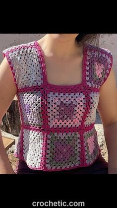 a woman is wearing a crocheted top with pink and white squares on it