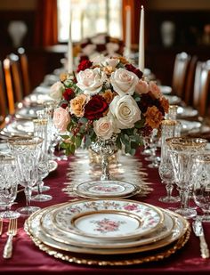 a table set with plates, silverware and flowers