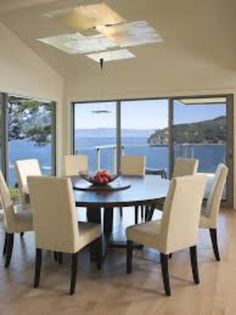 the dining room table is surrounded by beige chairs