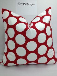 a red and white polka dot pillow sitting on top of a table