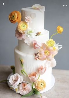 a white wedding cake with flowers on top