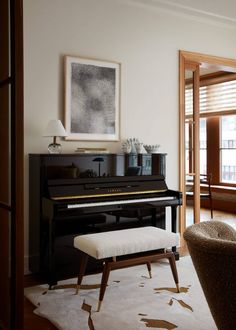 a piano in a living room next to a chair