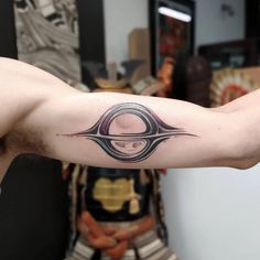 a man's arm with a tattoo on it that has an image of the letter o