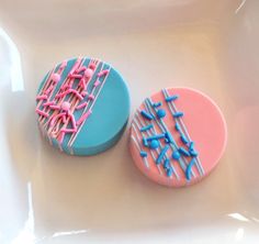 two decorated cookies sitting on top of a white plate