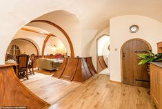 a living room filled with furniture next to a kitchen and dining room table in front of an arched doorway