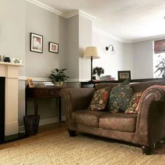 a living room with a couch, fireplace and pictures on the wall in it's corner