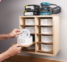 a person is holding a roll of paper in front of a cabinet with numbers on it