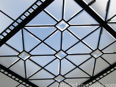 the ceiling is made up of metal squares and triangles, which are connected to each other