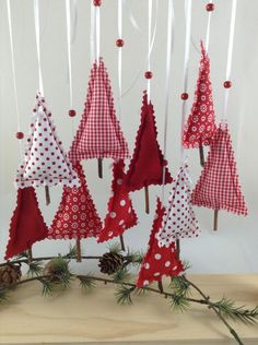 red and white christmas trees are hanging on sticks