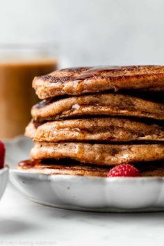 stack of pancakes with raspberries and syrup