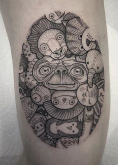 a black and white tattoo on the leg of a person with an animal head in it