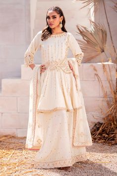 Bright White Pakistani Wedding Dress Embroidered Gharara Frock is adorned with hand-crafted details of crystals, pearls, motifs, and stones. Lavish designs and premium quality fabric make this Pakistani Wedding Dress your foremost priority for the wedding to have a head-turning look White Embellished Palazzo Set For Designer Wear, Embellished White Palazzo Set For Designer Wear, Designer Embellished White Palazzo Set, Floor-length Sharara With Dupatta For Ceremony, White Salwar Kameez With Pearl Embroidery For Reception, Cream Sharara For Eid Reception, Embellished White Georgette Palazzo Set, White Embellished Georgette Palazzo Set, Designer White Salwar Kameez With Pearl Embroidery