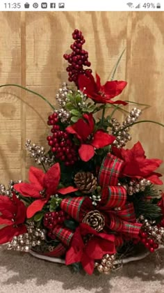 a christmas tree with poinsettis, pine cones and red berries on it