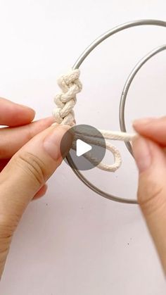 two hands are tying a rope around a circle with one hand and the other hand