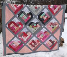 a quilt hanging on a clothes line in the snow