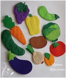 felt fruits and vegetables are arranged on a white surface