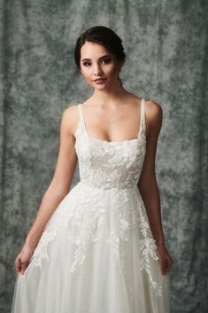 a woman in a wedding dress posing for the camera with her hand on her hip