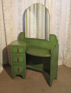 a green dresser with a mirror on top of it next to a curtained window