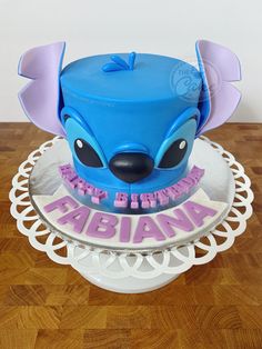 a blue and purple birthday cake sitting on top of a wooden table