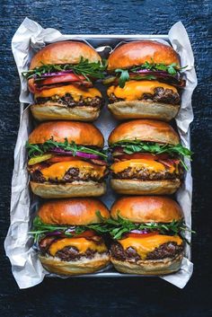 several hamburgers with cheese and lettuce on them