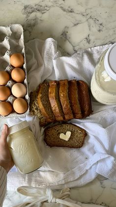 bread, eggs and butter on a towel next to a container of yogurt