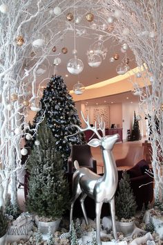 a christmas display in a living room filled with trees and ornaments