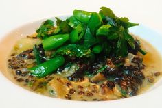 a white plate topped with green vegetables and sauce