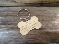 a wooden keychain with a dog bone on it that says, oes escape must call my agent