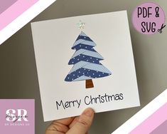 someone holding up a christmas card with a tree on it