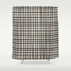 a black and white checkered shower curtain on a stand in front of a wall