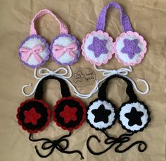 four crocheted purses with bows and hearts on them sitting on a piece of paper