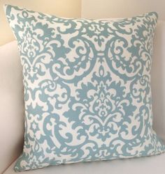 a blue and white pillow sitting on top of a couch