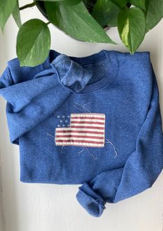 Elegant and Classic Vintage Style American Flag Crewneck Sweater. Please note that sweaters need to be washed once for the fabric will start to fringe. Long Sleeve Americana Sweater For Fall, Americana Long Sleeve Sweater For Fall, Fall Americana Long Sleeve Sweater, Winter Cotton Tops With Embroidered Patch, Winter Cotton Top With Embroidered Patch, Vintage Cotton Sweater With Embroidered Graphics, Vintage Embroidered Cotton Sweater, Patriotic Blue Tops For Fall, Long Sleeve American Style Cotton Sweatshirt