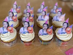 cupcakes with pictures of women and cats on them sitting on a plastic tray