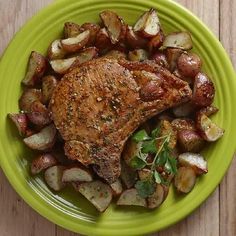 a green plate topped with meat and potatoes