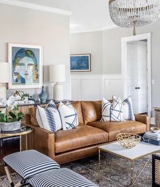 a living room filled with furniture and a chandelier hanging above the couches