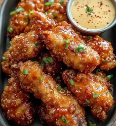 a black plate topped with chicken wings and dipping sauce