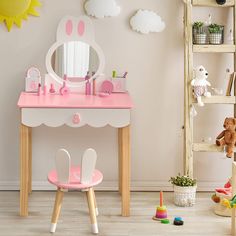 a child's desk with a mirror, toy stool and teddy bear on the floor