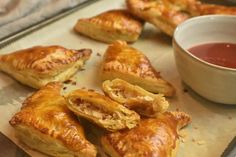 several pastries on a tray with dipping sauce